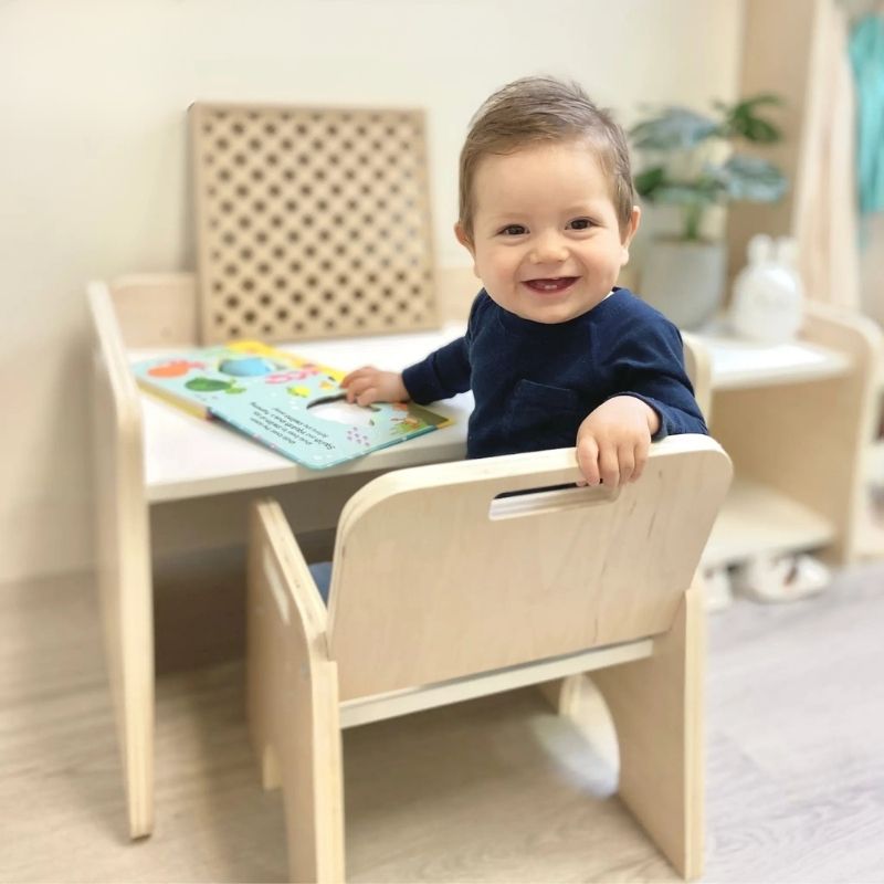 Sapiens Child Papaya Set Montessori weaning table and chair with child actively playing indoors, showing the compact child-height workspace for meals, sensory activities, and Montessori materials