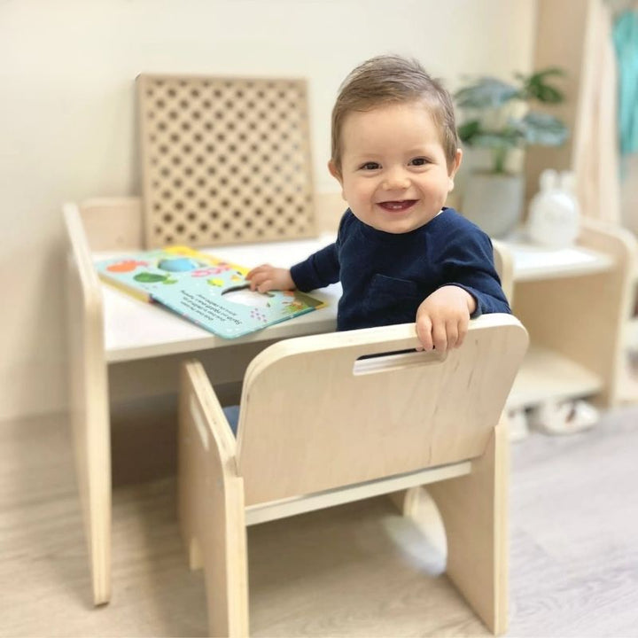 Sapiens Child Papaya Set Montessori weaning table and chair with child actively playing indoors, showing the compact child-height workspace for meals, sensory activities, and Montessori materials