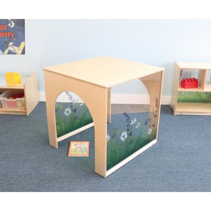 Whitney Brothers Nature View Play House Cube set up as a reading nook in an early learning classroom beside coordinating Nature View Collection shelving