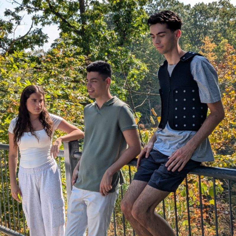 Power WearHouse ProPower Compression Vest for Adults modelled in a group outdoor setting, showing the slim profile and adult-specific design for daily sensory regulation