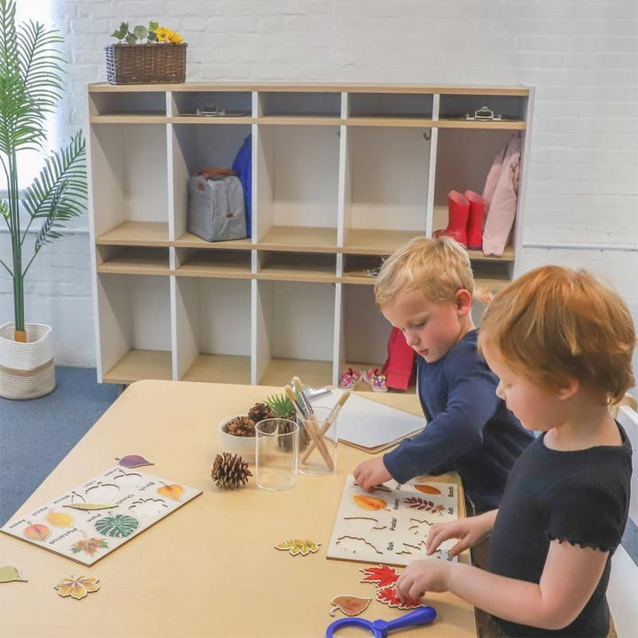 Children doing leaf puzzles in front of the Whitney Brothers elevatED 10 Section Coat Locker, classroom cubbies with hooks keeping bags and rain boots tidy