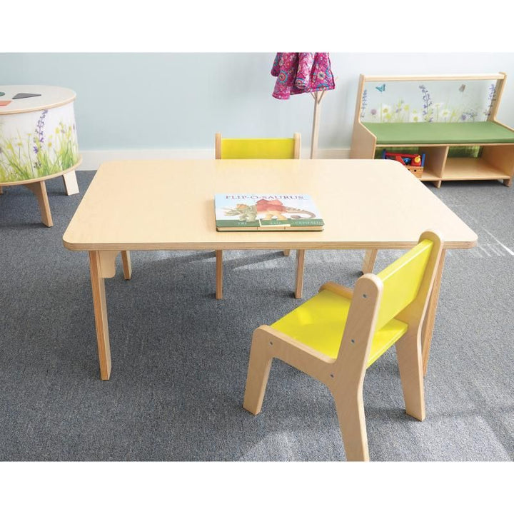 Whitney Plus Rectangle Table by Whitney Brothers at 20 inches with a picture book and yellow chairs, a preschool rectangle table for reading and daycare spaces