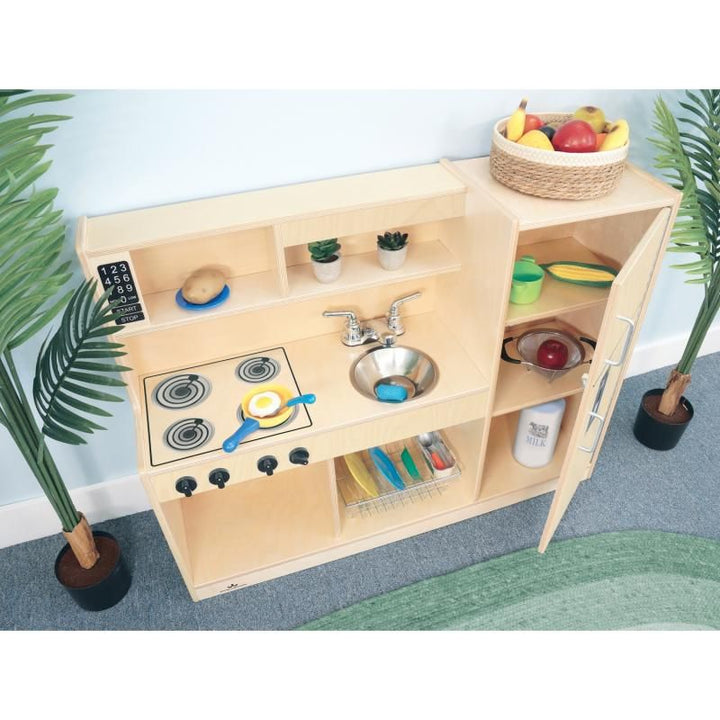 Let's Play Toddler Kitchen Combo by Whitney Brothers with the refrigerator door open on its piano hinge, showing shelves stocked for pretend play kitchen fun