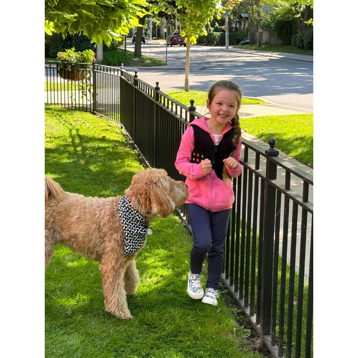Child wearing Power WearHouse ProPower Compression Vest outdoors with a pet, demonstrating comfortable everyday wear for sensory regulation