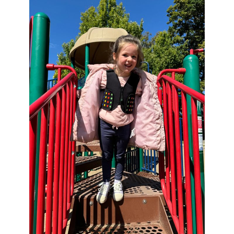 Child wearing the Power WearHouse ProPower Compression Vest at a playground, showing the vest in active daily wear for proprioceptive sensory support