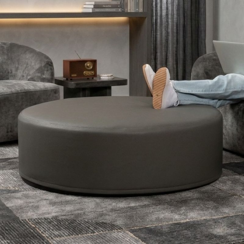 Jaxx Candler round ottoman in grey, flexible foam seating styled in a modern living room setting