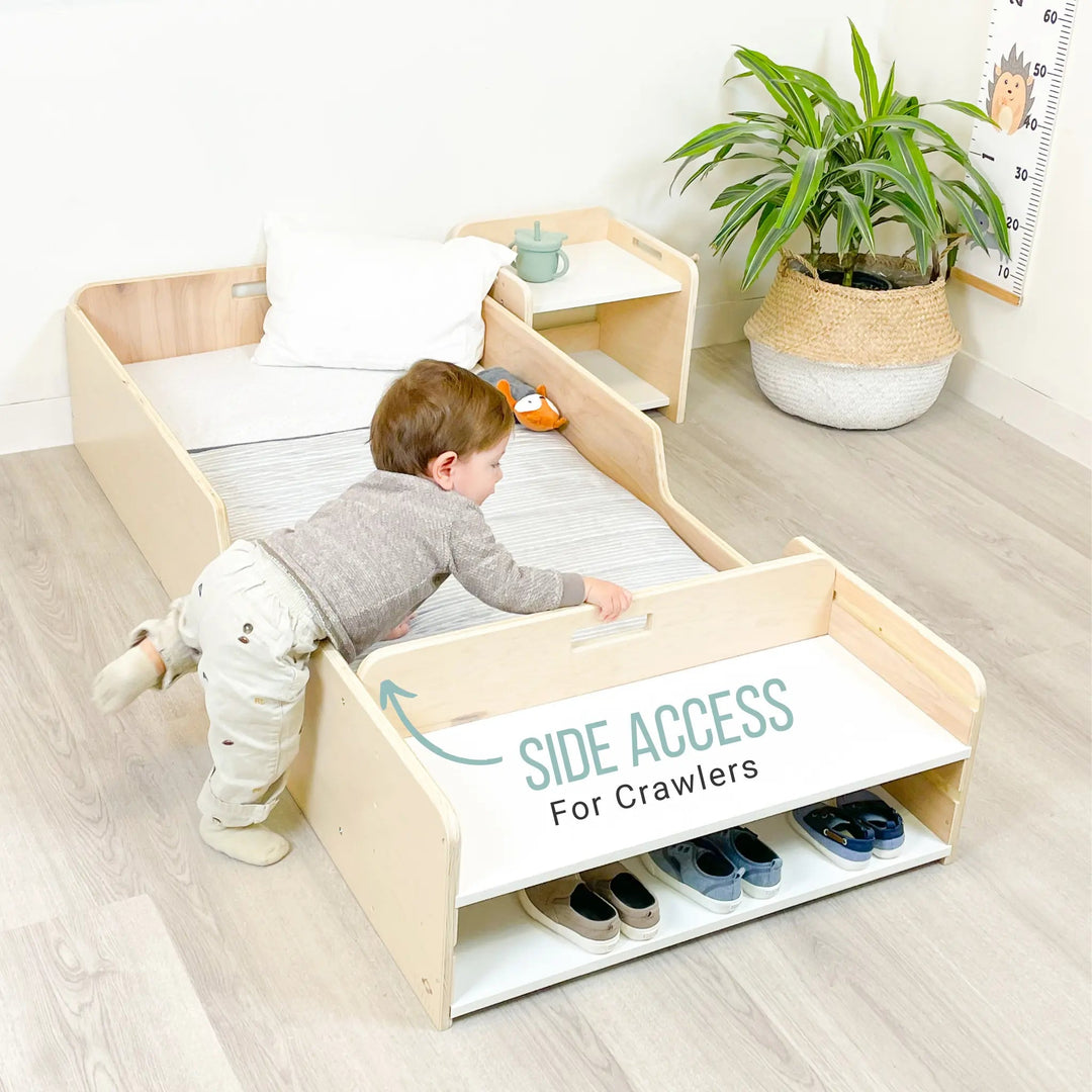 Toddler crawling into the Sapiens Child Apple Montessori floor bed with rails from the open side, showing the low-profile design that supports independent toddler access