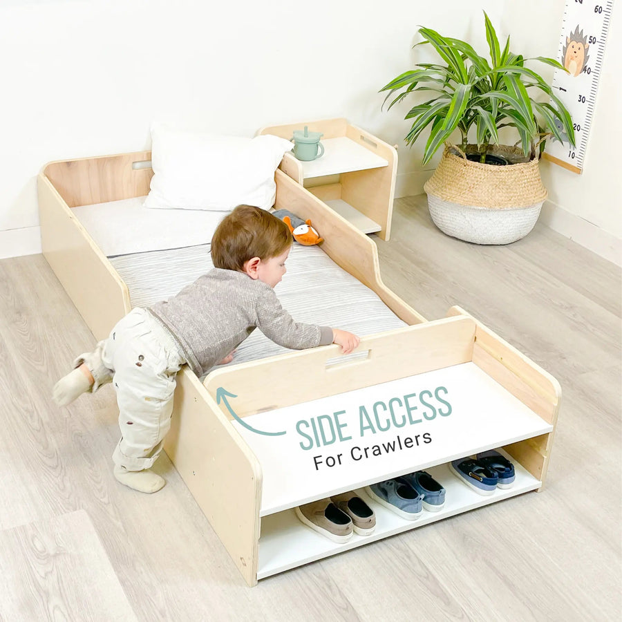 Toddler crawling into the Sapiens Child Apple Montessori floor bed with rails from the open side, showing the low-profile design that supports independent toddler access