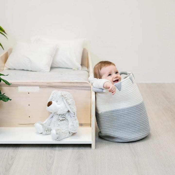 Sapiens Child Apple Montessori floor bed with rails showing the integrated adjustable side shelf for books, toys, and toddler essentials at child height