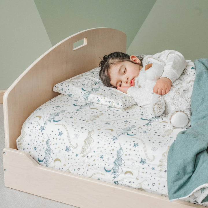 Child sleeping on the Sapiens Child Cherry Montessori floor bed, showing the comfortable low-to-ground sleeping environment for toddlers and kids across North America