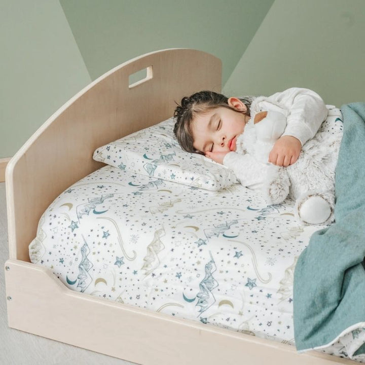 Child sleeping on the Sapiens Child Cherry Twin Montessori floor bed, showing the comfortable low-profile sleeping environment for kids across North America