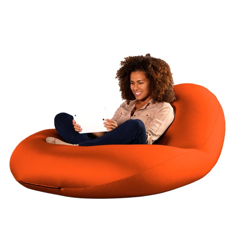 A woman sits cross-legged with a tablet in the orange Jaxx Nimbus sensory bean bag chair, demonstrating upright sensory seating support