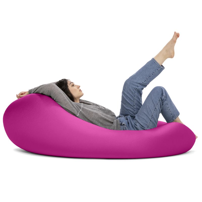 A woman reclines in the pink Jaxx Nimbus sensory bean bag chair, showing the flat, flexible seating position of this stretchy spandex chair