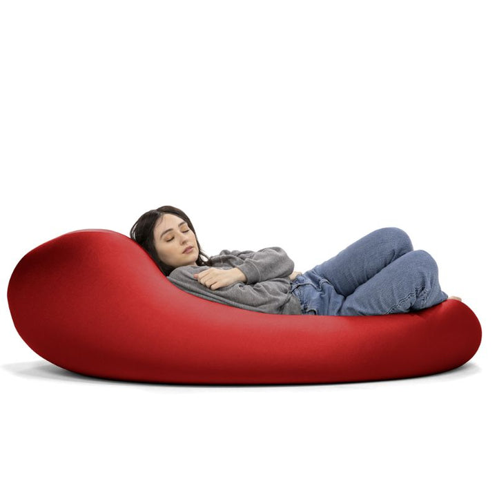 A woman rests in the red Jaxx Nimbus sensory bean bag chair, showing how the stretchy spandex cover adapts to a flat lounging position