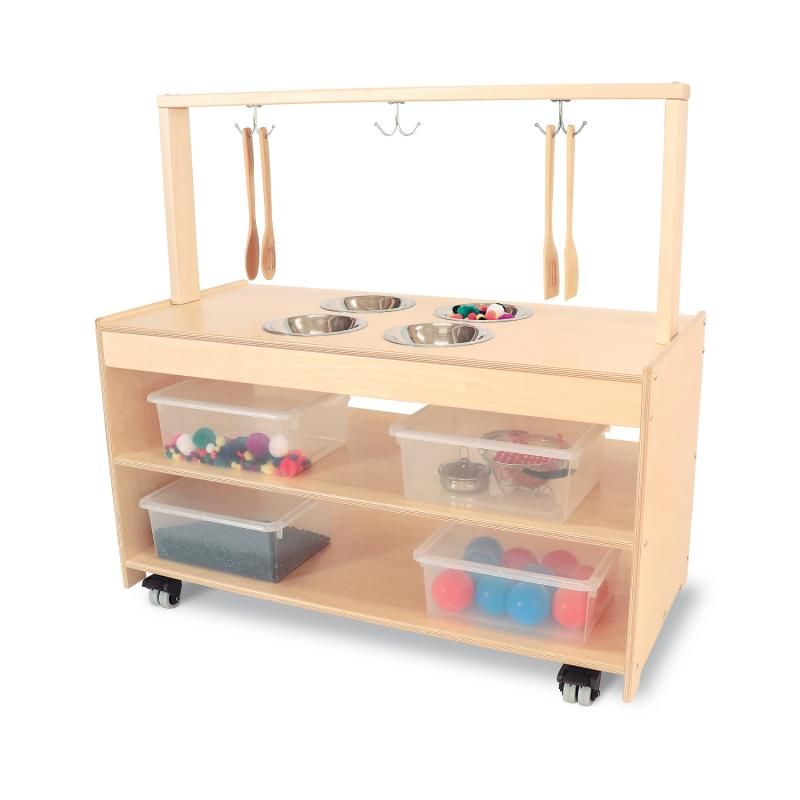 Whitney Brothers Mobile Sensory Play Kitchen with four stainless steel mixing bowls, hanging utensils and clear lidded bins filled with tactile play materials