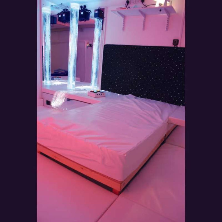 TFH Waterbed with Platform positioned beside bubble tubes and a mirror wall in a fully equipped sensory room