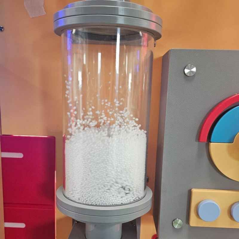 LiteZilla Hurricane Tube sensory wind tube filled with white foam beads inside the clear acrylic column, mounted beside a colorful control panel