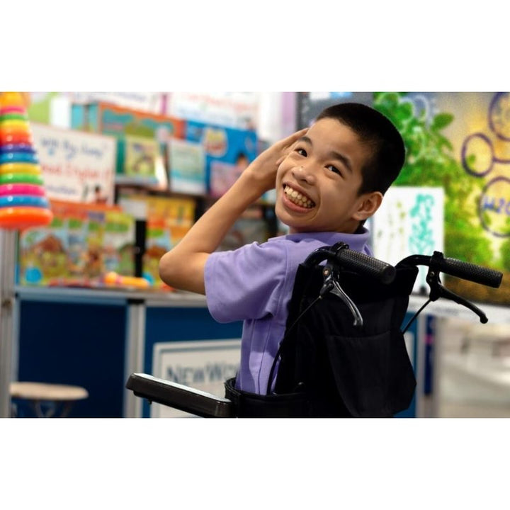 Child smiling and actively engaged with the SMART Board RX Series interactive display in an inclusive classroom setting