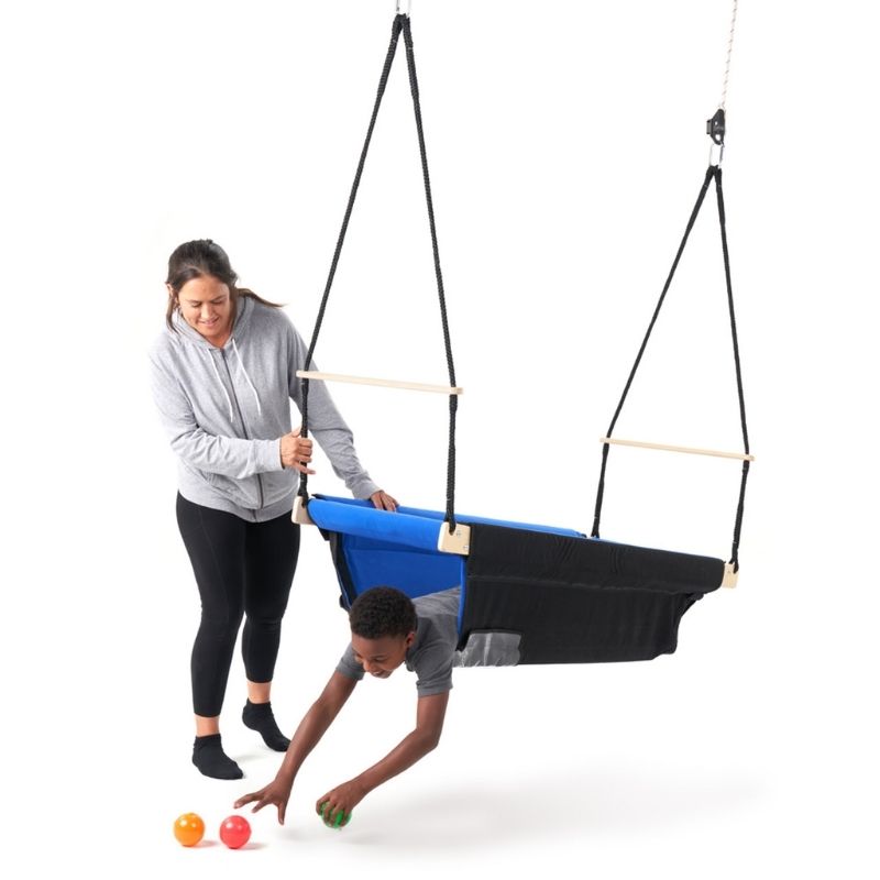 A boy and adult woman using the Southpaw Buddy Boat sensory swing, demonstrating the large interior and multi-position use in a therapy or home setting