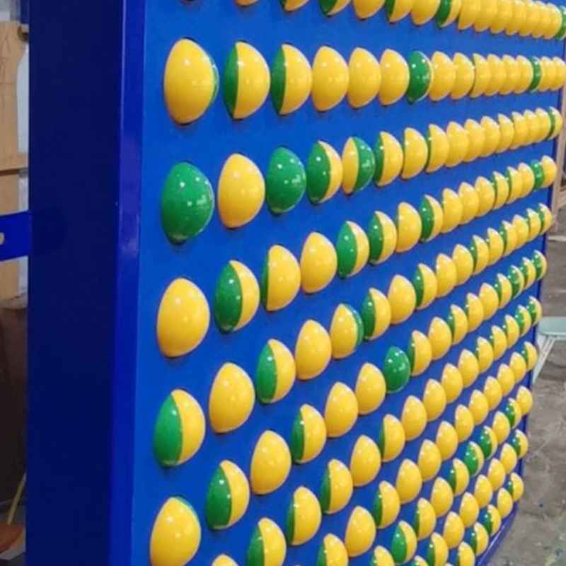 Close angled detail of LiteZilla Spinfinity Wall interactive spinning wall panel spheres in yellow and green during production
