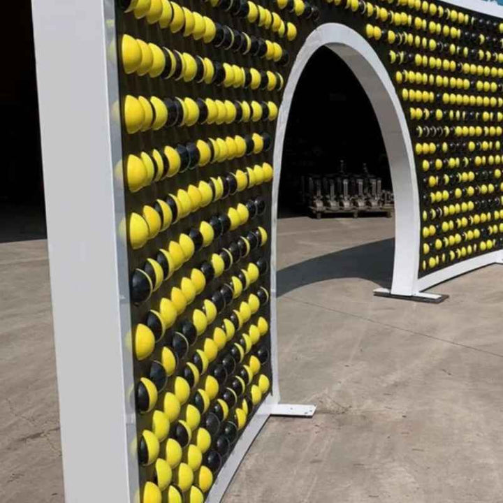 LiteZilla Spinfinity Wall interactive spinning wall panel installed as an archway feature with black and yellow sphere shapes