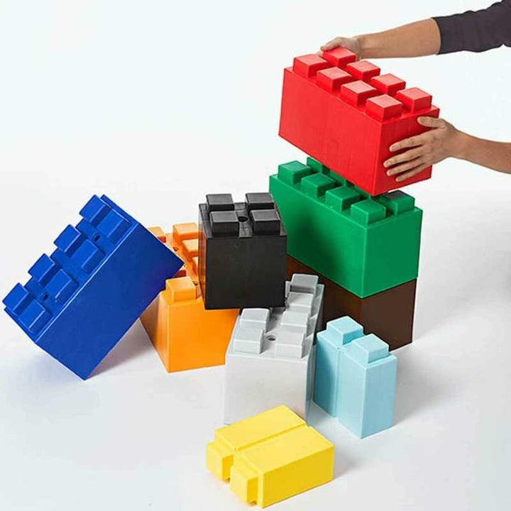 Hands stacking a giant EverBlock STEM building block to show the interlocking connection system