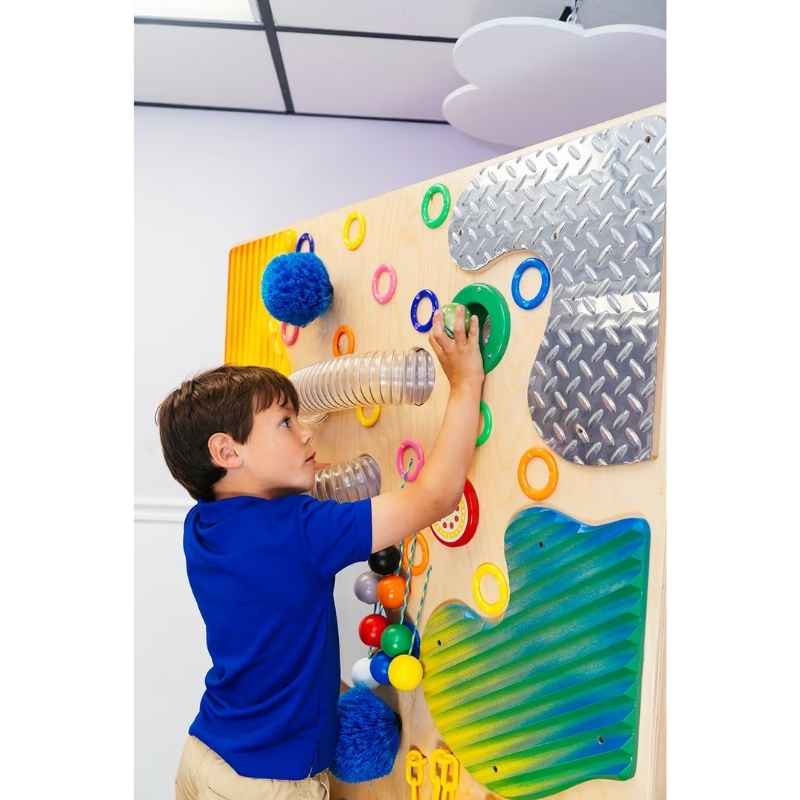 Child reaching up to explore the TFH Tactile Loopie Wall interactive tactile wall panel mounted in a sensory room
