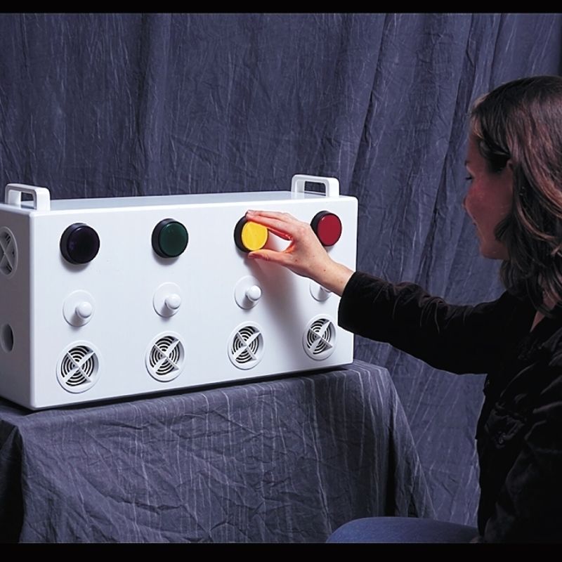 Adult using the TFH Aroma Fan & Light Reward System, a button-activated multi-sensory aromatherapy diffuser for therapy rooms