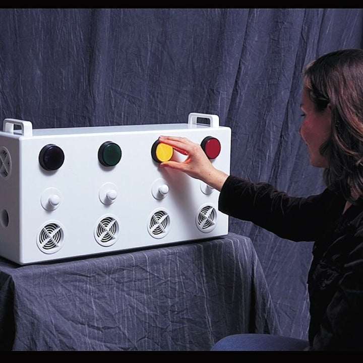 Adult using the TFH Aroma Fan & Light Reward System, a button-activated multi-sensory aromatherapy diffuser for therapy rooms