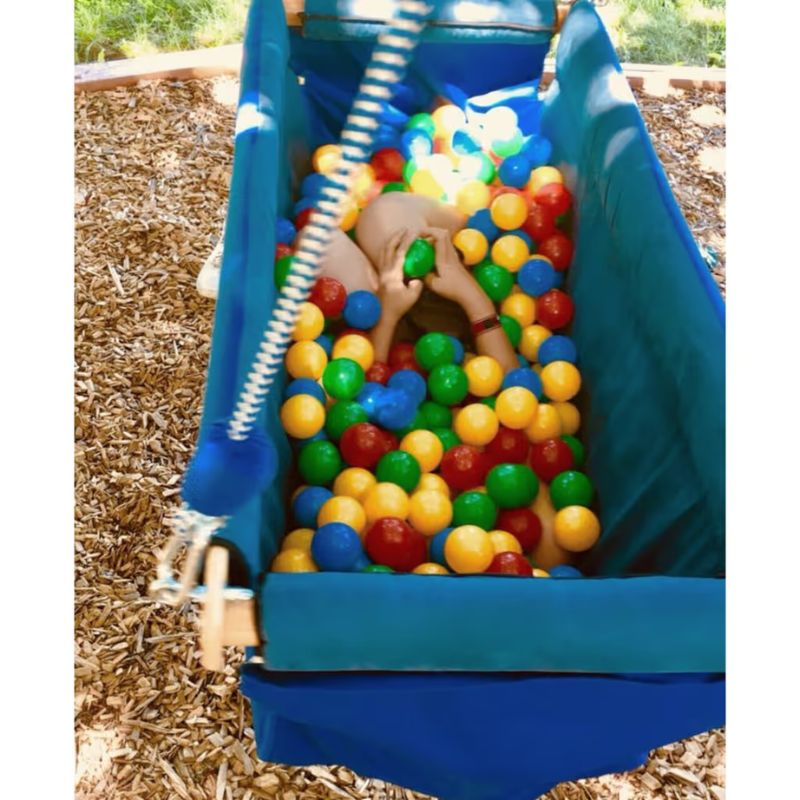 Overhead view of the TFH Deep Boat Swing filled with sensory balls, showing the enclosed nylon design used for deep pressure and vestibular input