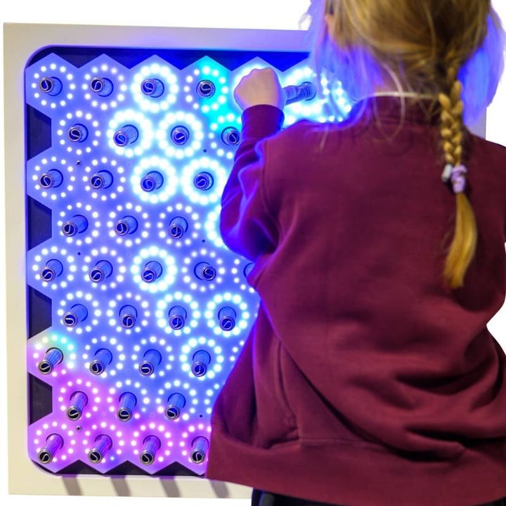 Child engaging with the TFH Electro Wobble Garden Activity Panel showing the full 60 x 60cm touch-responsive spring-sensor surface in a sensory room setting