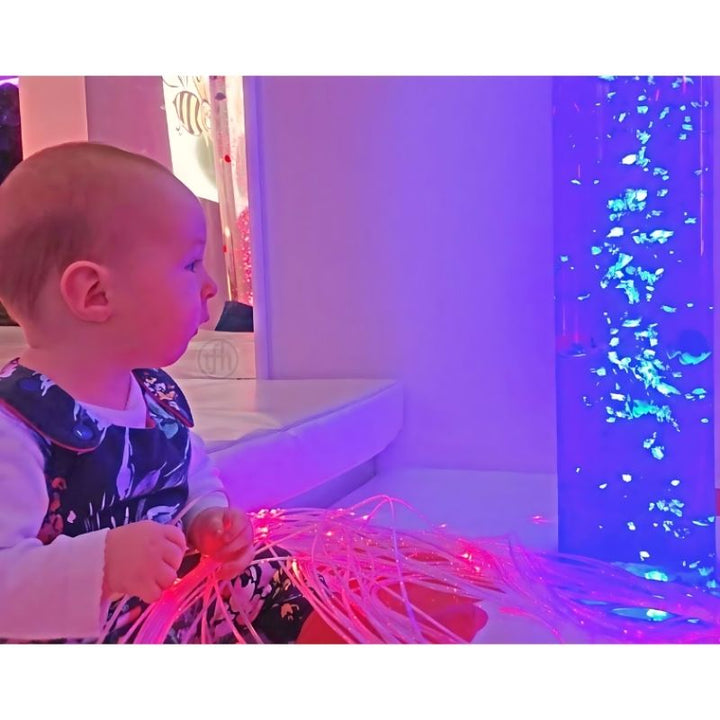 Child playing with TFH Fibre Optic Tails from side view, showing the full 80-inch strand length during active sensory exploration