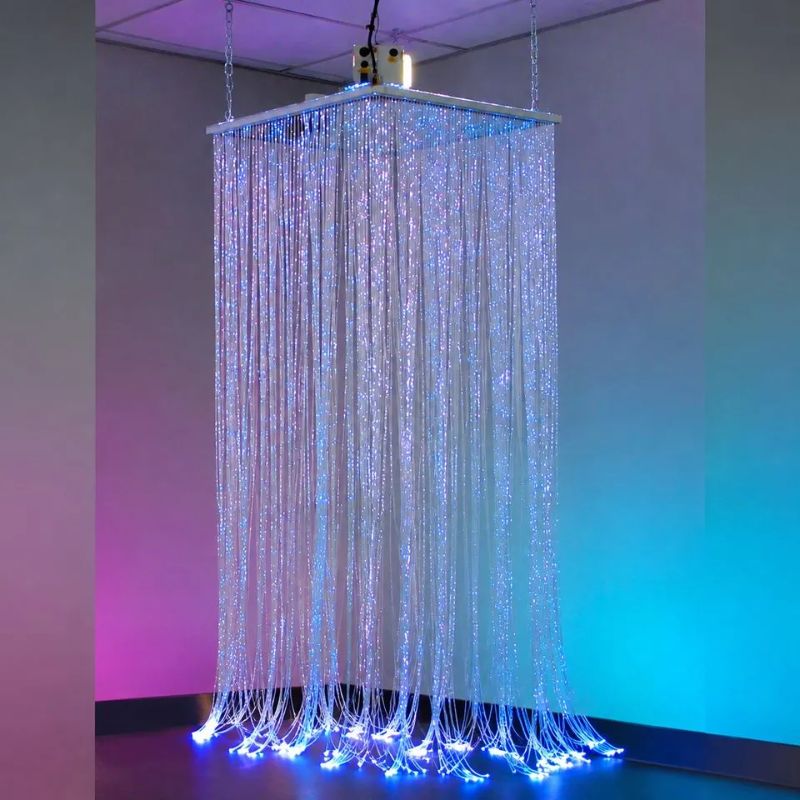 Full TFH Fibre Optic Waterfall installation hanging from its 24" square shelf, 200 blue-lit fibre optic tails cascading to the floor of a sensory room