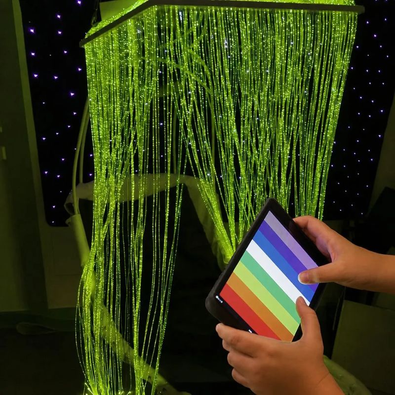 Hands choosing a colour on the MSE Genie App to turn the TFH Fibre Optic Waterfall Genie Controlled System green, giving users Bluetooth colour control