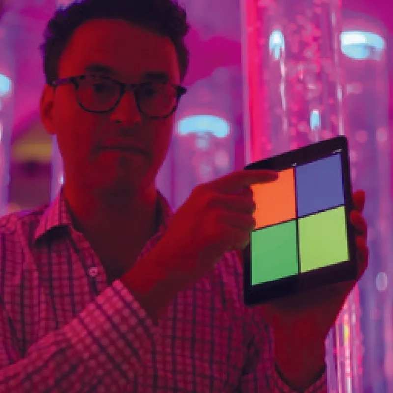 Facilitator using the MSE Genie app on a tablet to adjust colour settings in a multi-sensory room with the TFH Genie Receiver