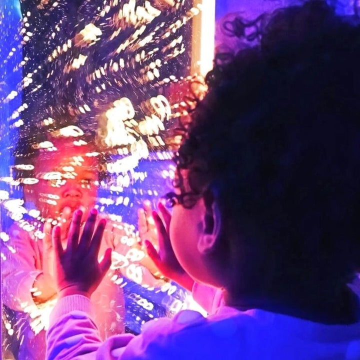Close-up of a child actively engaging with the TFH Infinity Bubble Wall, supporting sensory exploration, visual tracking, and tactile stimulation