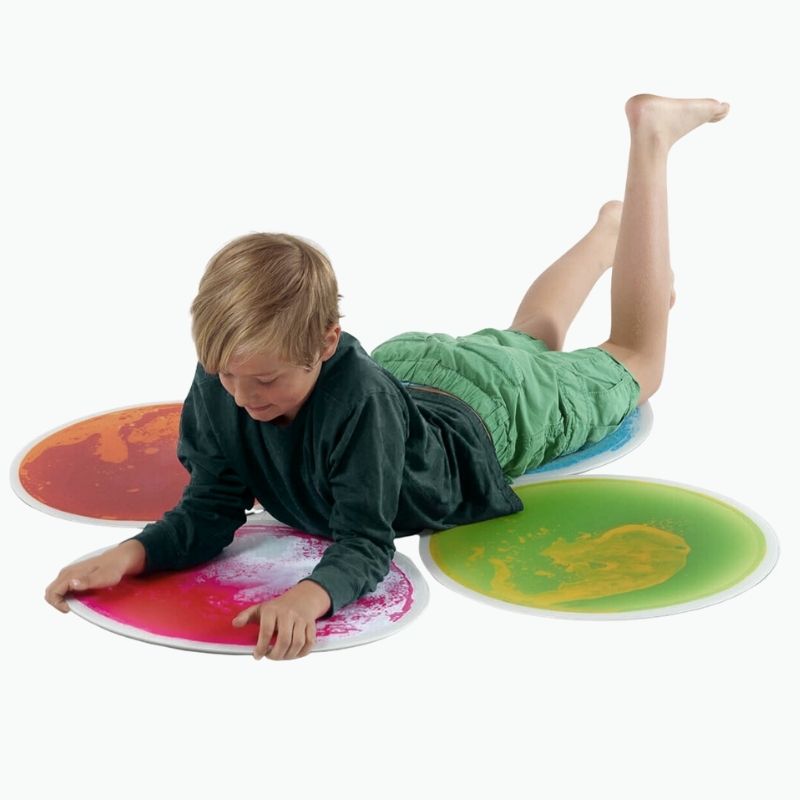 Child stepping on the TFH Large Circle Liquid Floor Tiles 4 Set, showing the 50cm colour-shifting gel tiles in active use for gross motor and sensory play