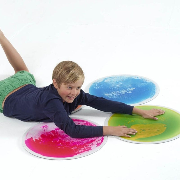 Second child actively using the TFH Large Circle Liquid Floor Tiles 4 Set, demonstrating stepping stone pathway play and proprioceptive sensory floor tile engagement