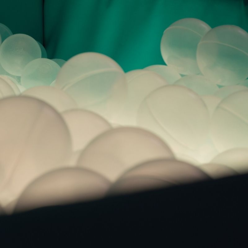 Close-up of TFH Large Light-Up Ball Pit showing translucent sensory balls in cool white-blue LED light