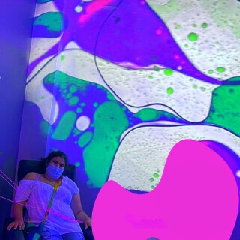 TFH Sensory Room Magic Genie System Starter landscape view with an adult actively engaging with the interactive multi-sensory room, showing the bubble tube, fibre optic tails and projection environment