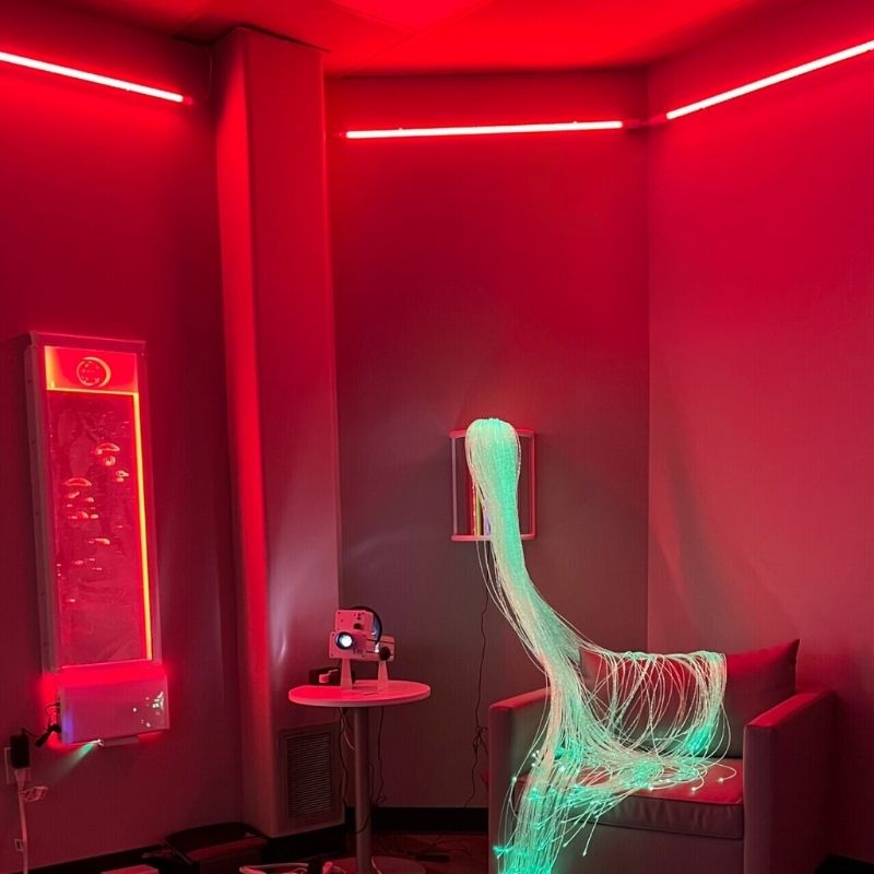 TFH Sensory Room Magic Genie System Starter landscape view in red MSE Genie lighting showing the interactive colour wash and bubble tube creating an immersive multi-sensory room atmosphere