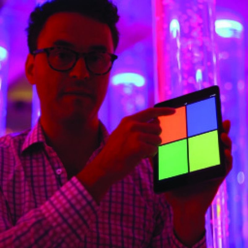 TFH Sensory Room Magic Genie System Starter with an adult holding the universal wireless colour controller, demonstrating hands-on Bluetooth control of the interactive multi-sensory room equipment