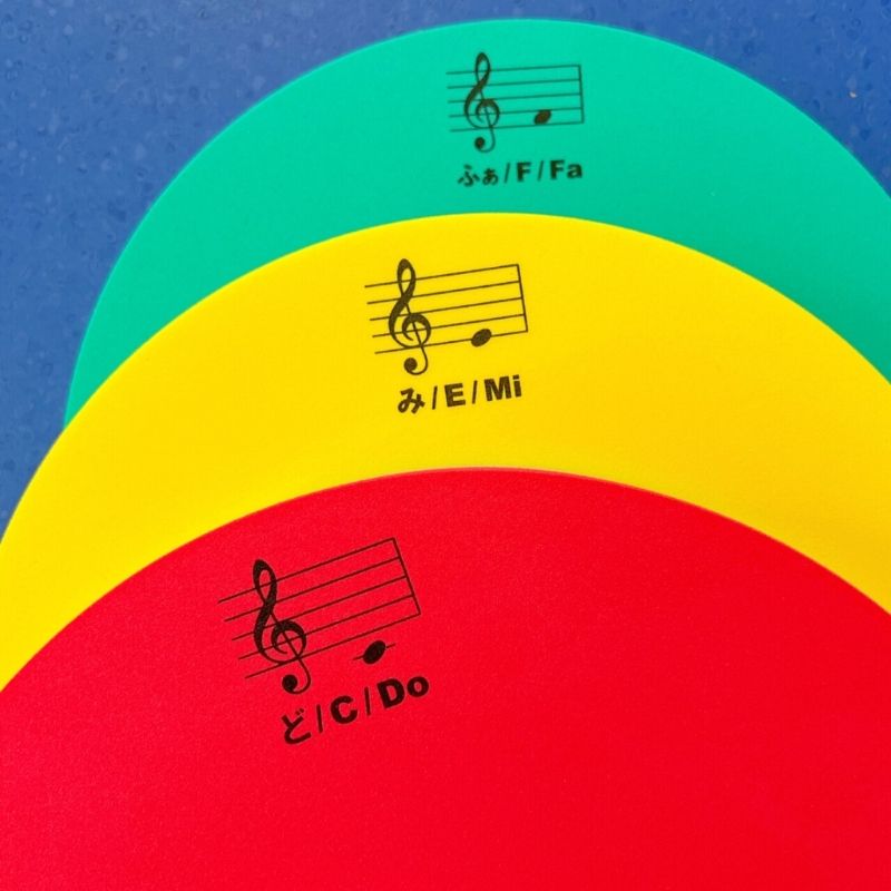 Close-up of a TFH Musical Stepping Notes pad showing the Suzuki reed stepping surface with musical note name and treble clef staff notation printed on the pad