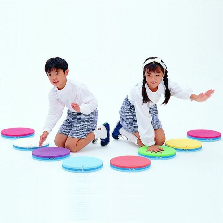 Two children playing together on TFH Musical Stepping Notes, demonstrating group sensory music activity with the acoustic stepping pad set
