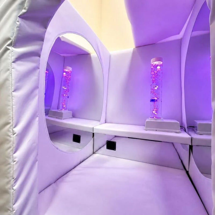 TFH Deluxe Portable Sensory Den interior glowing purple, showing the bubble tube, box seat, acrylic mirror and padded floor of this portable sensory space