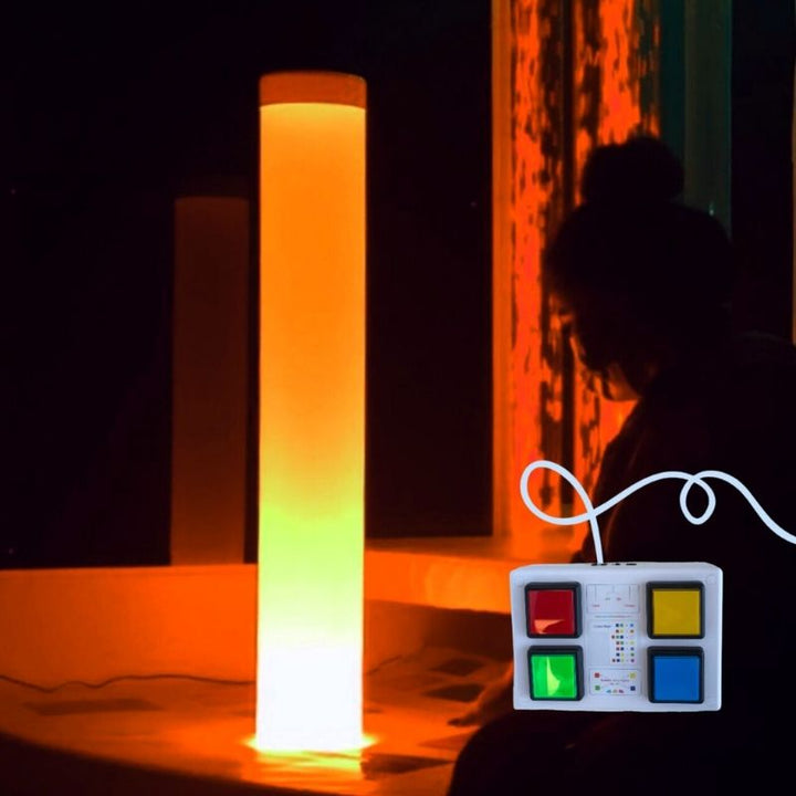 TFH Rainbow Frosted Tube casting warm orange light in a darkened sensory room, demonstrating the visual stimulation and calming atmosphere created by the waterless bubble column