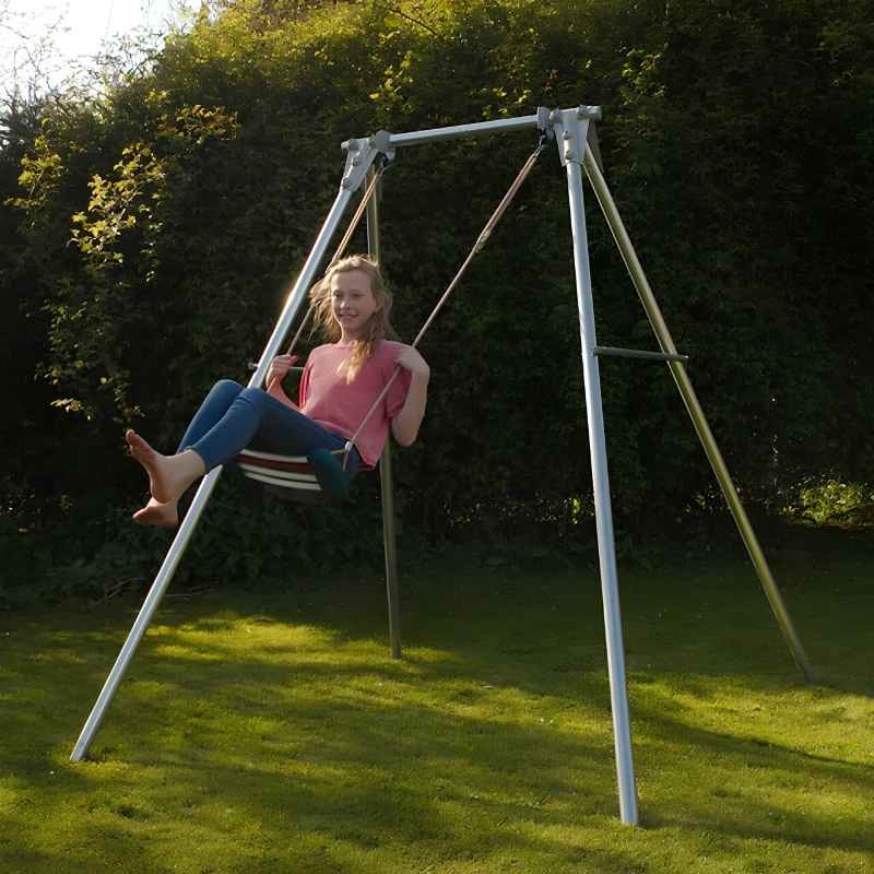 Child swinging on a fabric seat attached to the TFH Sensory Swing Frame set up outdoors in a backyard sensory space