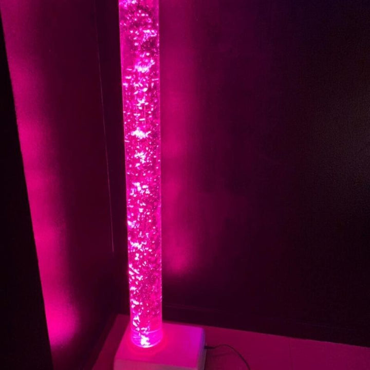 TFH Small Bubble Tube 4-inch wide in corner room placement with pink LED light showing the slim 4-inch diameter profile ideal for small sensory rooms, calm corners and bedrooms