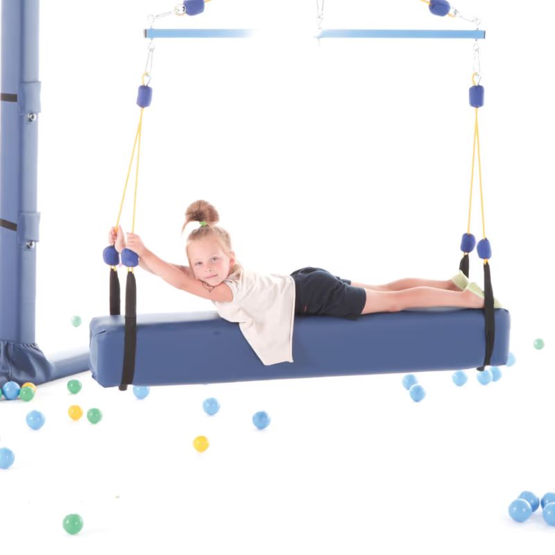 Child lying across the TFH Square Glider Bolster Swing suspended from a four point frame, gliding gently for vestibular play and balance support at home or in therapy