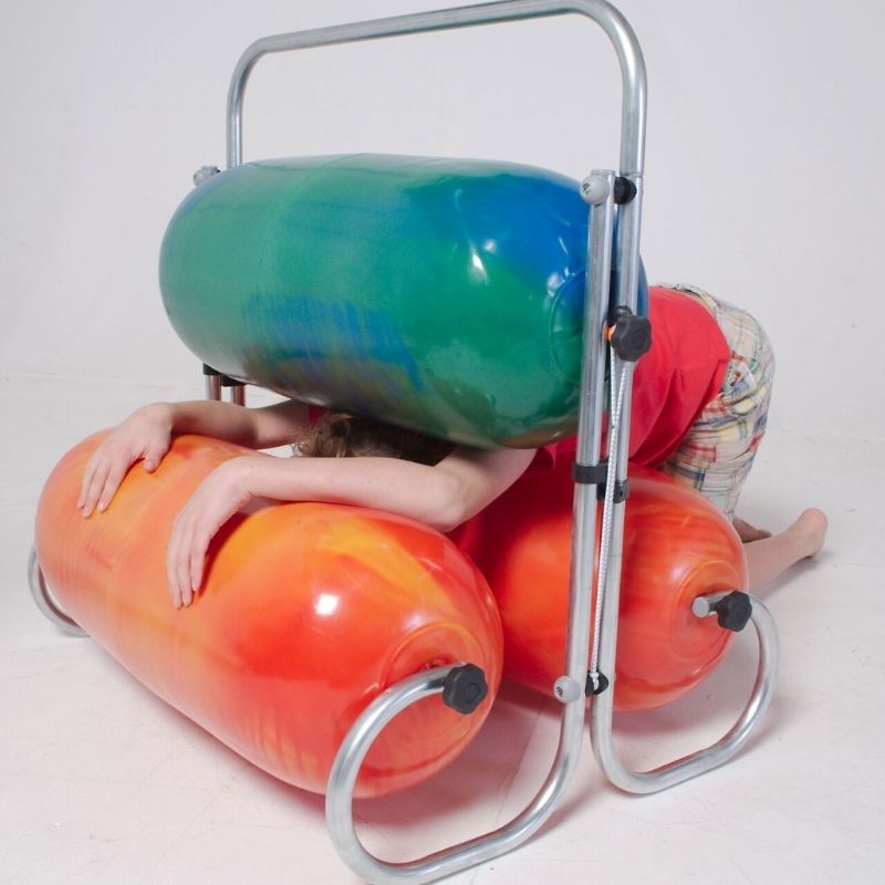 Child squeezing through the TFH Squeeze Machine inflatable rollers, experiencing adjustable deep pressure therapy for sensory regulation and body awareness